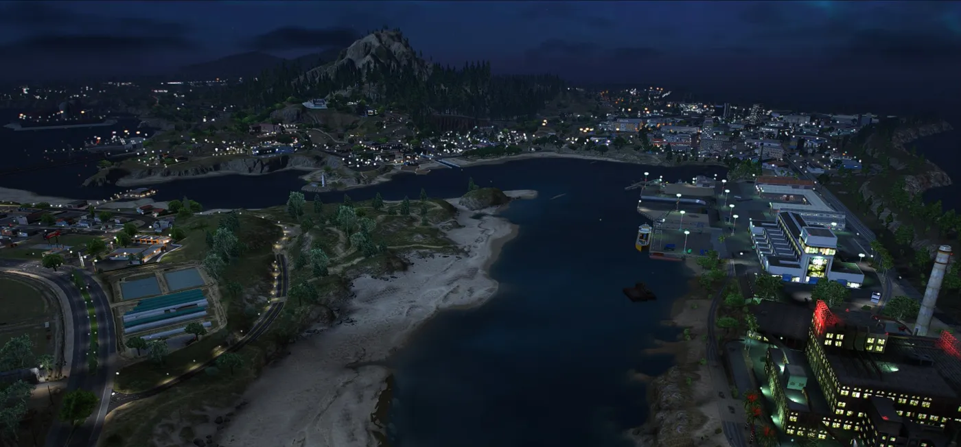 Roxwood at night from high above a bay, with a lit harbour, ferry and warehouses on the right, a sandy beach in the middle and the town spread along the far shore beneath a forested mountain